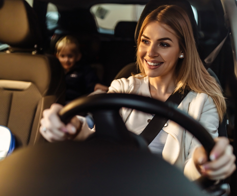 Woman and child smile on board of a car.