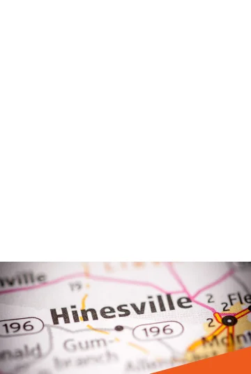 Hinesville, Georgia on a road map: Cheap car insurance in The Peach State. Image 2: Historic antebellum home in the Peach State with oak trees and flowers: