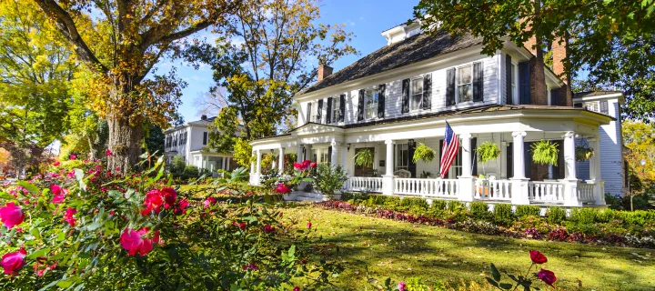 Historic antebellum home in the Peach State with oak trees and flowers: Cheap car insurance in Hinesville, Georgia.