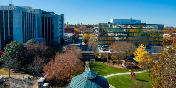 Aerial shot of a round blue and white pergola in Decatur Square with red and yellow autumn trees, lush green trees and grass, office buildings, and people with clear blue skies: Cheap car insurance in Decatur, Georgia.