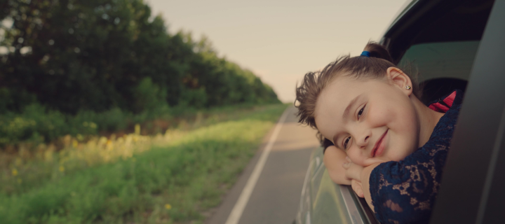 little girl, smile on her face, stuck her head out, car windows,