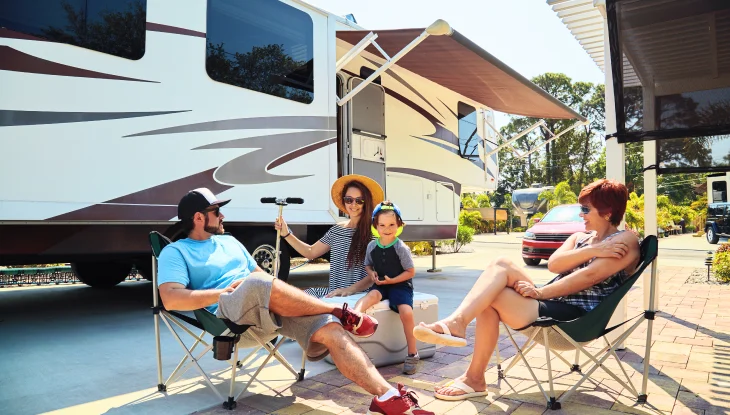Family sitting outside of rv.