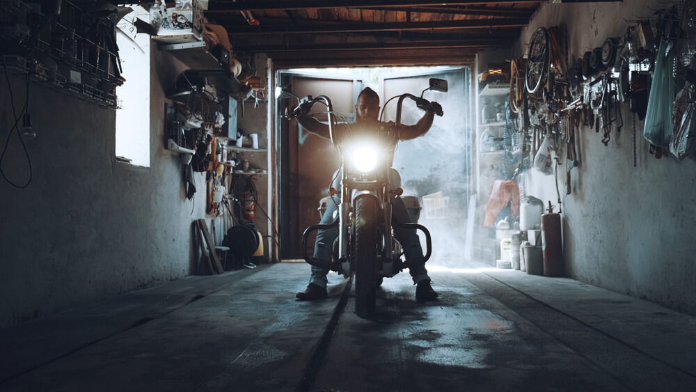 Man on a motorcycle inside a garage

